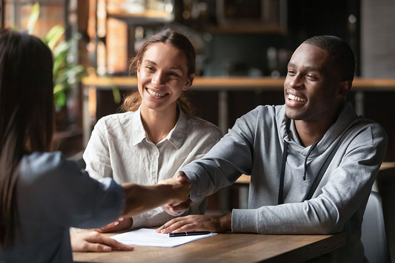 Couple shaking hands with loan officer